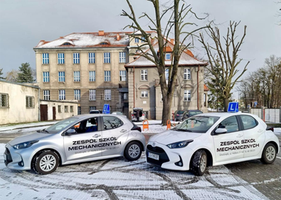 Samochody szkoleniowe Zespołu Szkół Mechanicznych przed budynkiem szkoły